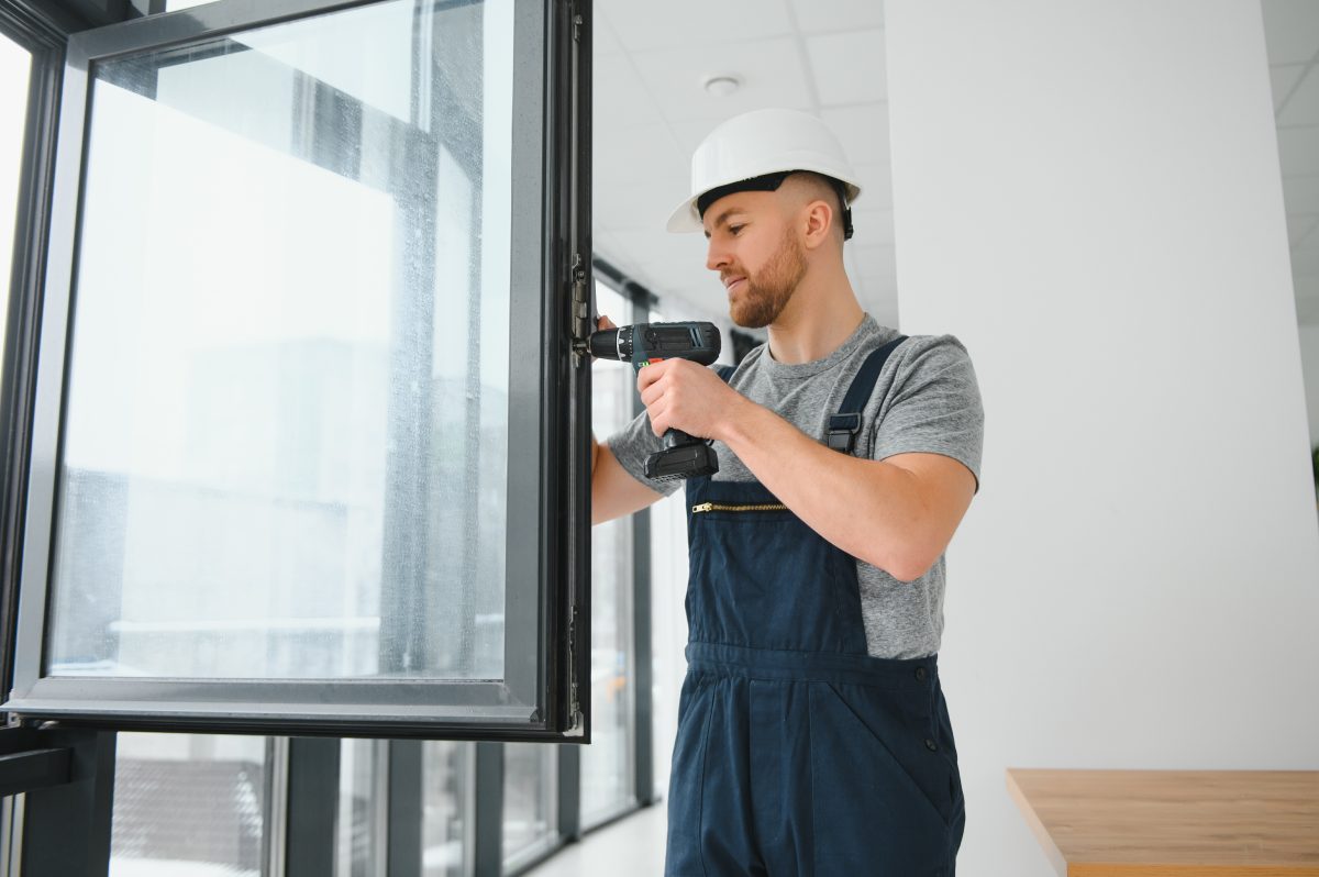 construction-worker-repairing-plastic-window-with-screwdriver-indoors-space-text-banner-design-1-scaled-1.jpg